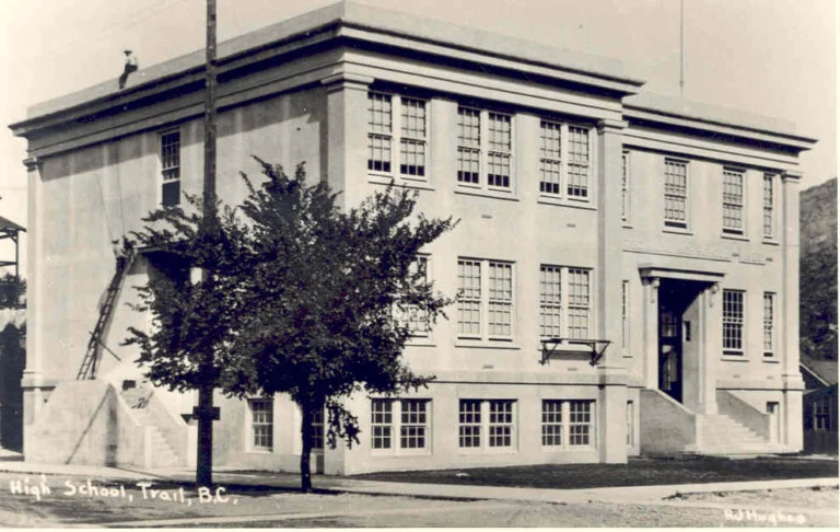 A historical black and white photograph of Trail Junior High School in British Columbia, presenting a solid, multi-story brick building with large windows and a central entrance, reminiscent of early 20th-century educational architecture.